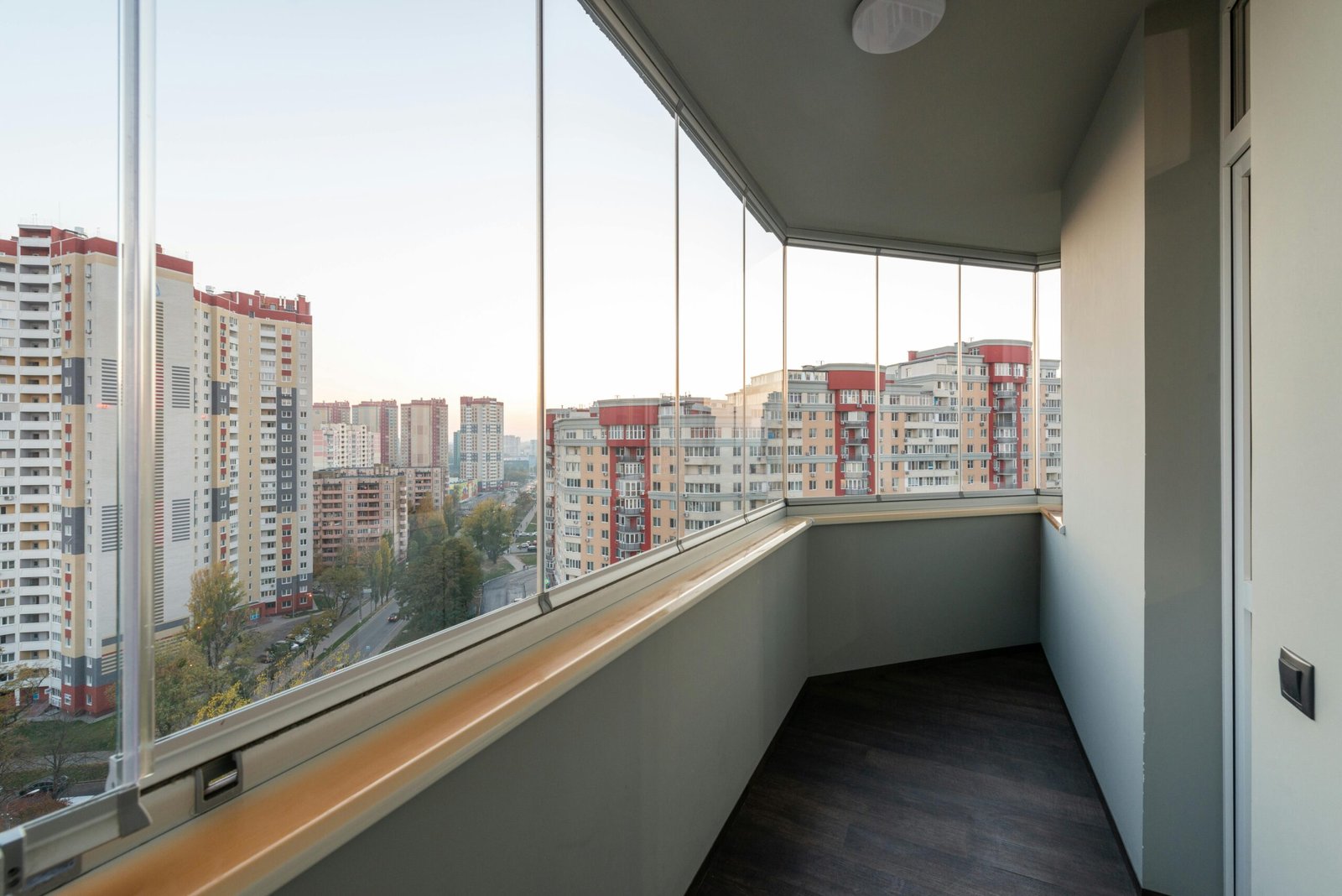 Varanda envidraçada de um prédio residencial com vista urbana, representando condomínios e residências